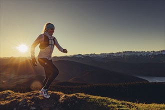 Trail running in autumn on the Jochberg on Lake Walchensee against the wonderful backdrop of the