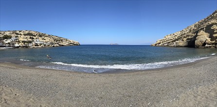 Panoramic photo of Matala bay front beach without beach chairs sunshades, Matala, Crete, Greece,