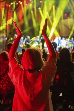 Person applauds at a night concert with red lights on stage, Klostersommer, Calw Hirsau, Black