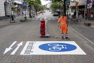 Application of road markings for a cycle lane, Rüttenscheider Straße in Essen, in the shopping and