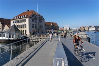 Cyclists on the Inderhavnsbroen cycle and footpath bridge, over the harbour, at Nyhavn, Copenhagen