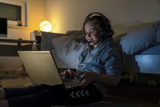 Boy, at home on the computer, laptop, in the children's room, playing a game, chatting with other