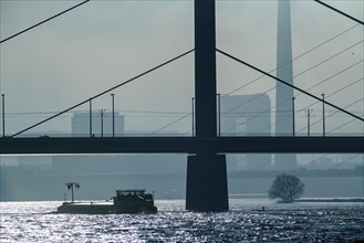 Dense fog slowly lifting, cargo ships on the Rhine near Düsseldorf, in front the Oberkassler