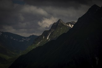 Grassy summit with remnants of snow and dramatic clouds, Lech, Lechquellengebirge, Vorarlberg,