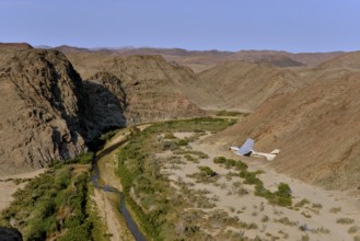 Small aircraft, Cessna 210 Centurion, above the dry riverbed of Hoarusib, Namib-Skeleton Coast