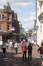 Shoppers walking in a pedestrianised shopping area in the town centre of Ipswich, Suffolk, England,