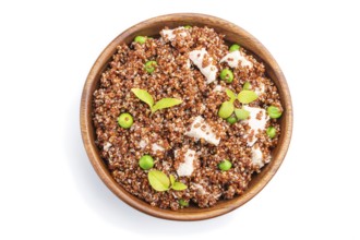 Quinoa porridge with green pea and chicken in wooden bowl isolated on a white background. Top view,