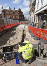 Male BT Openreach broadband technician working in town centre of Ipswich, Suffolk, England, UK