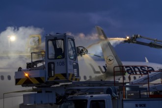 Winter at Frankfurt Main Airport, FRA, Lufthansa aircraft being de-iced by de-icing vehicles,