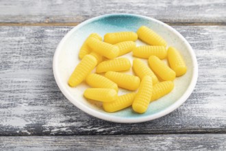 Jelly corn candies on gray wooden background. side view, close up