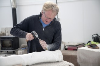 Sculptor working on local Portland stone in a community studio space on the Isle of Portland,