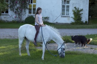 Girl, 10 years old sitting on her horse, Othenstorf, Mecklenburg-Vorpommern, Germany, Europe