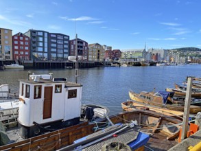 Boats in the harbour with colourful buildings and clear blue sky in the background, Nidarelva,