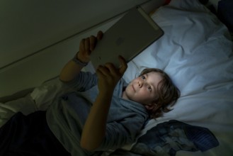 A boy plays computer games on a tablet PC