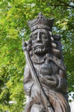 Wooden sculpture of a crowned king under green leaves, skilfully and richly detailed, Casimir I