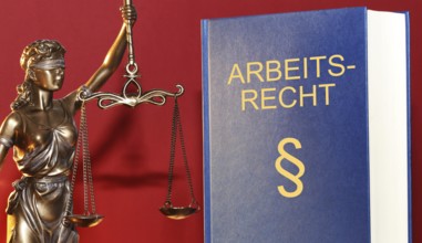 Symbolic image: Labour law reference book and a Justitia