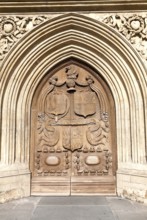 Detail of wooden door and stone arched entrance to the abbey church, Bath, Somerset, England,