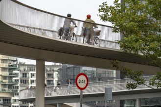 Cyclists on the Cykelslangen cycle and pedestrian bridge, at the Fisketorvet shopping centre,