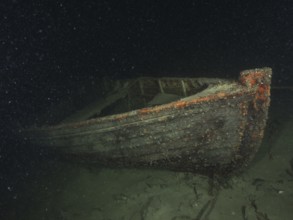 A shipwreck of a rowing boat lies on the sandy lake bottom, dive site Schoggiwand, Lake Zurich,