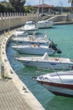 Leisure boats at quay in canal in Lido di Policoro resort, Basilicata, Mediterranean Sea, Italy,