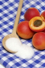 Apricots ( Prunus armeniaca) , Cooking spoon with sugar