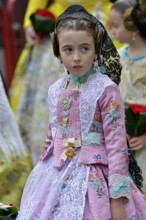 Fallas festival, girl in a traditional costume during the parade in the Plaza de la Virgen de los