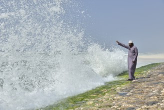 Local man watching the surf at the corniche of Salalah during the monsoon season, or Khareef