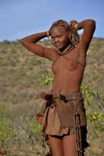 Young Himba woman doing her hair, Ombombo, Kaokoland, Kunene, Namibia, Africa