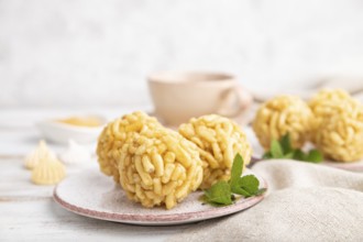 Traditional Tatar candy chak-chak made of dough and honey with cup of coffee on a white wooden