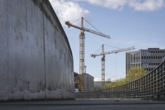 Two construction cranes in front of a blue sky in the Mitte district of Berlin, 28/03/2024