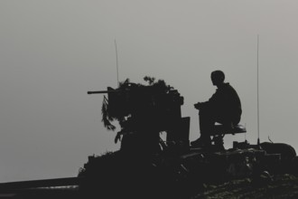 A soldier sits on a tank, taken as part of a Bundeswehr exercise with armed forces from Norway and