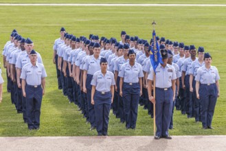 Flight of airmen in dress blues stand at attention during United States Air Force basic training