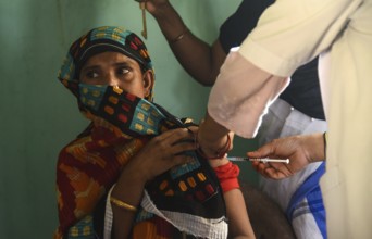 Beneficiaries receives dose of COVID-19 coronavirus vaccine in a vaccination centre at a village in