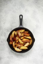 Fried potato slices, in a cast-iron pan, homemade, no people