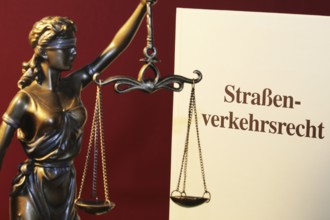 Symbolic image: Textbook on traffic law and a Justitia