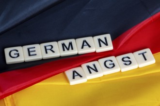 Symbolic image of German Angst: letter cube on a German flag