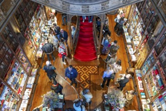 Shoppers browse books inside Livraria Lello bookstore in Porto, Portugal, Europe