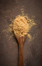 Wooden spoon with hazelnut flour, top view, no people, on a table