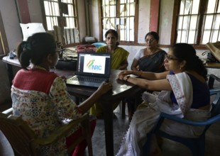 Officials checks the documents submitted by people at an National Register of Citizens (NRC) Seva