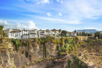 Famous Ronda restaurants and colonial houses overlooking the scenic gorge and the Puente Nuevo