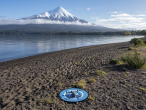 Drone on a landing pad at beach Playa Ensenada, lake Llanquihue, volcano Osorno, chilenean lake