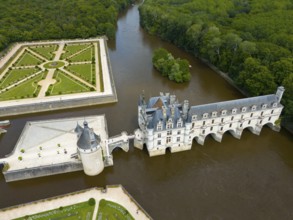 Historic castle with a Renaissance garden by a river and surrounded by dense forest, aerial view,