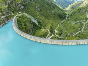 Dam of the Moiry lake, Lac de Moiry, turquoise glacial water, winding mountain road, aerial view,