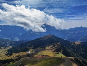 The Picberg, behind it the peaks of the Sassolungo Group, shrouded in mist, drone shot, Val