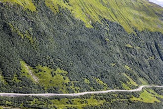 Landscape of the Swiss Alps above the tree line, motorhome travelling in a lonely area. Mountain