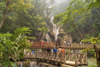 Tourists on the bridge at Kuang Si waterfall near Luang Prabang, Laos, Asia