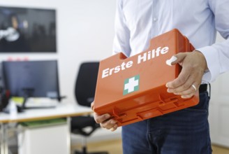 Occupational safety. A man holds a first aid kit in an office in Berlin, 09/08/2024