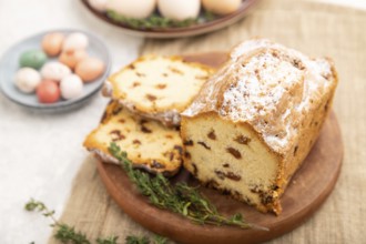 Homemade easter pie with raisins and eggs on plate on a gray concrete background and linen textile.