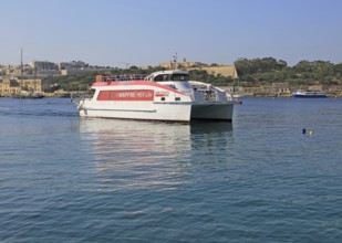 Mapfre Topcat ferry boat crossing harbour from Valletta to Sliema, Malta passing Fort Manoel