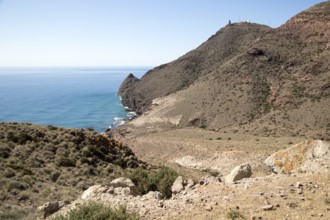 Coastal landscape Cabo de Gata natural park, looking west to Vela Blanca tower, Almeria, Spain,